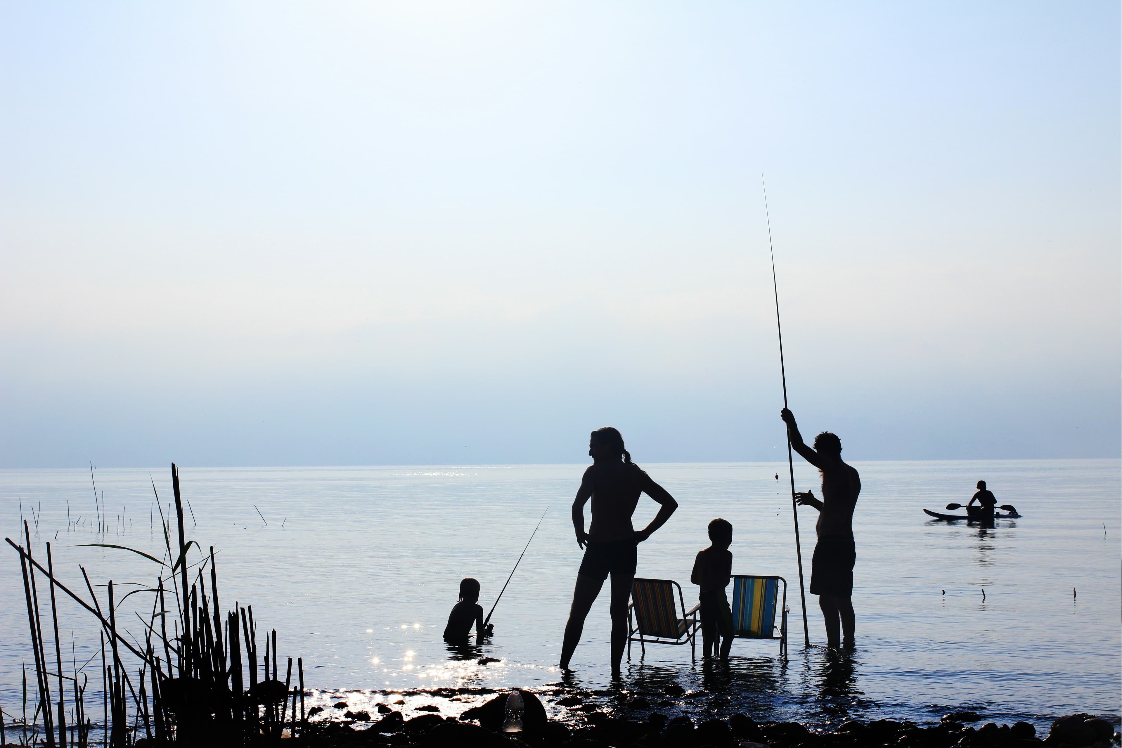 silhouette of people standing on water during daytime WMjqzYGoU5w